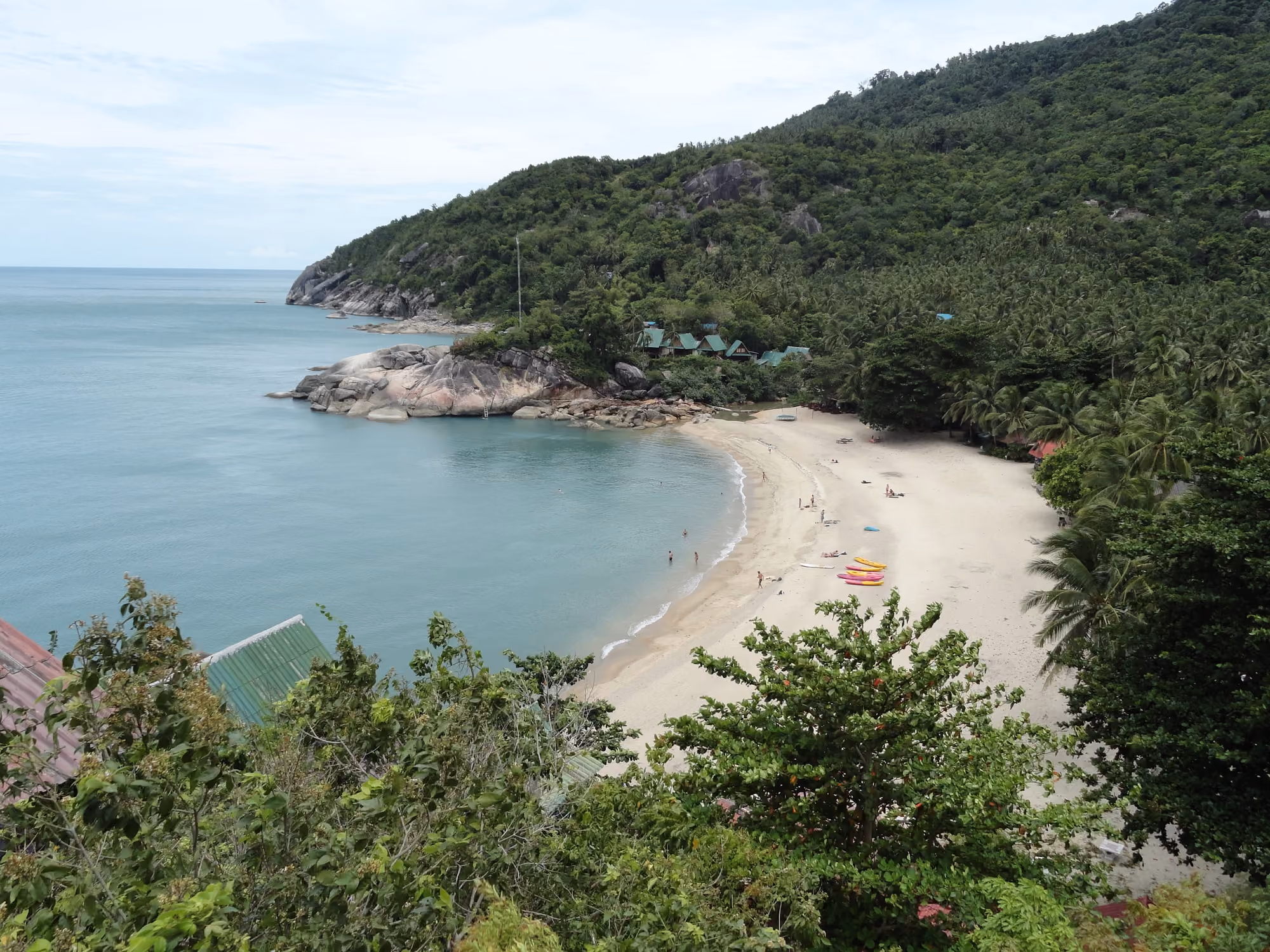 The small cove of Than Sadet on the east coast seen from the hillside, a pale sand beach between granite rocks and jungle